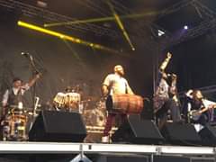 Image may contain: 1 person, on stage and playing a musical instrument