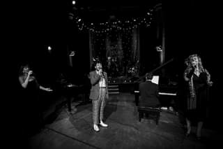 Image may contain: 3 people, people playing musical instruments, people dancing, people on stage, night and indoor