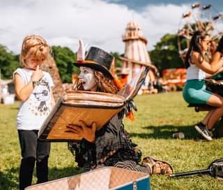 Image may contain: 1 person, dancing, standing, on stage, sky, hat and outdoor