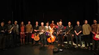 Image may contain: 6 people, people playing musical instruments, people on stage, people dancing and night