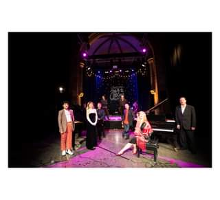 Image may contain: 2 people, people dancing, people playing musical instruments, people on stage, night and indoor