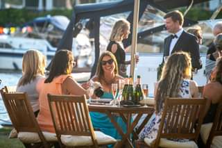 Image may contain: 2 people, people sitting, table and outdoor