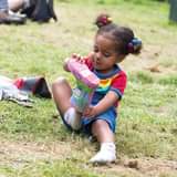 May be an image of child, footwear and grass