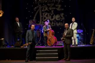 May be an image of 4 people, people playing musical instruments, people standing and indoor