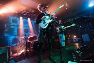 May be an image of 2 people, people playing musical instruments, people standing, guitar and indoor