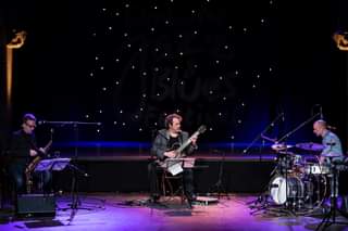 May be an image of 2 people, people playing musical instruments, guitar and indoor