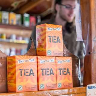 May be an image of 1 person and text that says "Tiny Tea Tent t5m) e Sustaineble Tiny Tea Tent Tiny Tea Tent Tiny Tea Tent TEA TEA TEA Sustainable Ethical Sustainable bags Ecological ALLERG Our C"