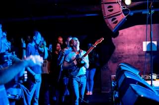 May be an image of 2 people, people playing musical instruments, people standing, guitar and indoor