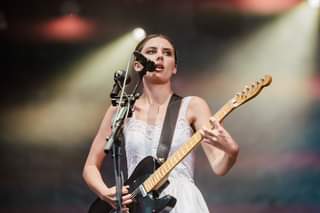 May be an image of 1 person, standing, playing a musical instrument and guitar