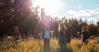 May be an image of 2 people, child, people standing, grass, nature and tree