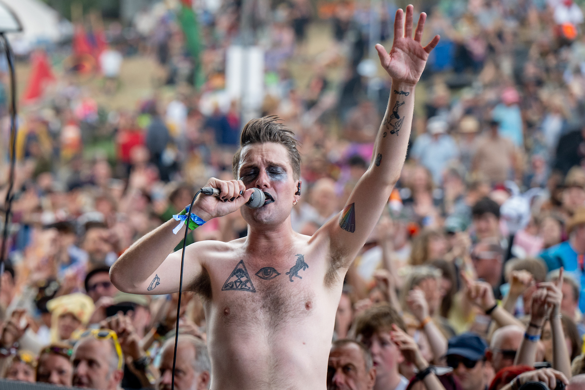 Erotic Secrets of Pompeii's singer with arm raised in front of a big crowd